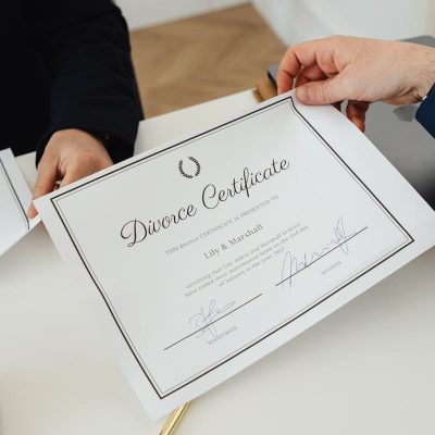 Overhead view of hands exchanging a divorce certificate in a professional environment.