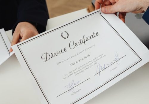 Overhead view of hands exchanging a divorce certificate in a professional environment.