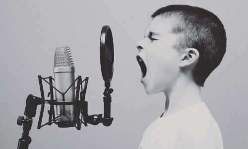 boy singing on microphone with pop filter
